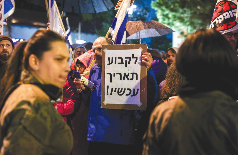  AT A PROTEST in Tel Aviv last month, a demonstrator holds a sign that reads: ‘Set a date now!’ a reference to the call for an early Knesset election. (credit: ITAI RON/FLASH90)