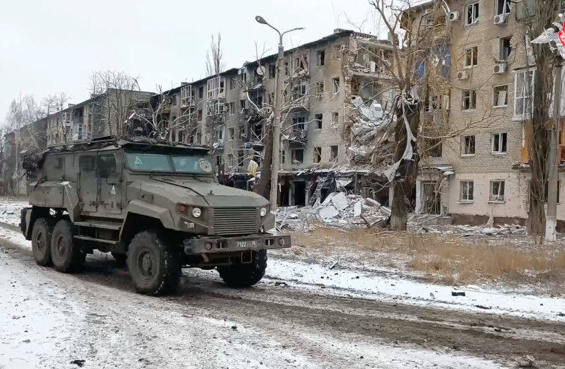  A Russian military vehicle drives past residential buildings damaged in the course of Russia-Ukraine conflict in the town of Avdiivka in the Donetsk Region, Russian-controlled Ukraine, in this image taken from video released February 20, 2024 (credit: RUSSIAN DEFENSE MINISTRY/HANDOUT VIA REUTERS)
