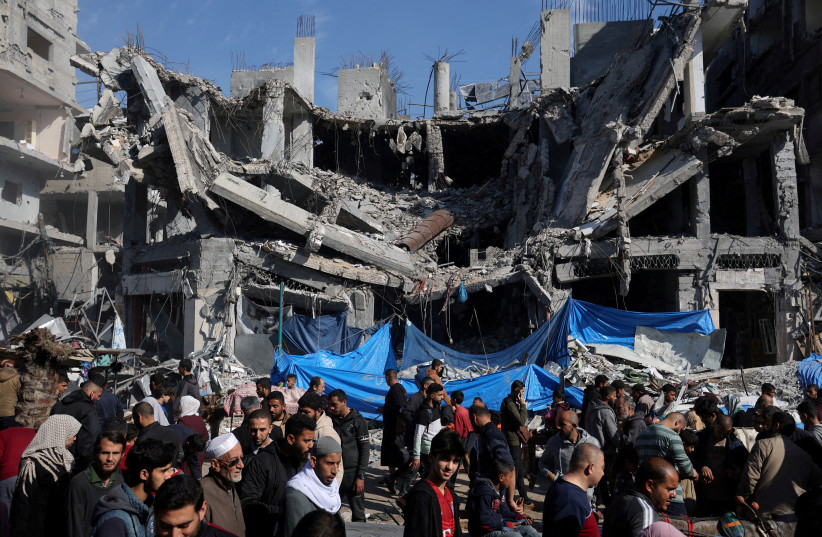  Palestinians shop in an open-air market near the ruins of houses and buildings destroyed in Israeli strikes during the conflict, amid a temporary truce between Hamas and Israel, in Nuseirat refugee camp in the central Gaza Strip November 30, 2023. (credit: IBRAHEEM ABU MUSTAFA/REUTERS)