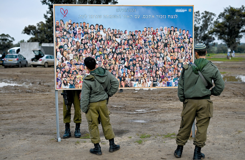  Soldiers visit the site of the Supernova music festival, where photographs are displayed of the people who were killed or kidnapped during the October 7 attack by Hamas.  (credit: DYLAN MARTINEZ/REUTERS)