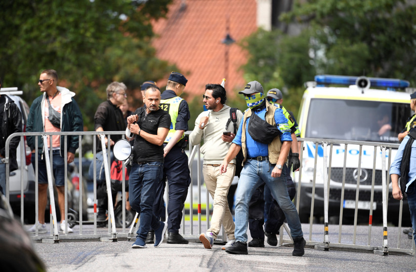Protestor Salwan Momika, who planned to burn a copy of Koran and the Iraqi flag, is escorted by police to a location outside the Iraqi embassy, in Stockholm, Sweden July 20, 2023 (credit: TT News Agency/Caisa Rasmussen via REUTERS)