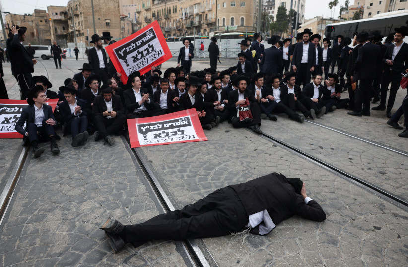 Ultra-Ortodox Jewish men protest against attempts to change government policy that grants ultra-Orthodox Jews exemptions from military conscription in Jerusalem February 26, 2024. (credit: RONEN ZVULUN/REUTERS)