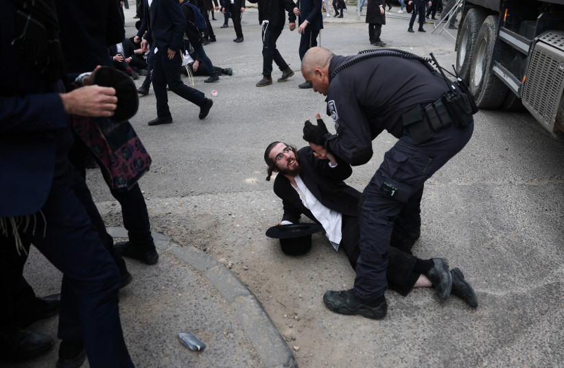 A protester is detained as Ultra-Ortodox Jewish men protest against attempts to change government policy that grants ultra-Orthodox Jews exemptions from military conscription in Jerusalem February 26, 2024. (credit: RONEN ZVULUN/REUTERS)