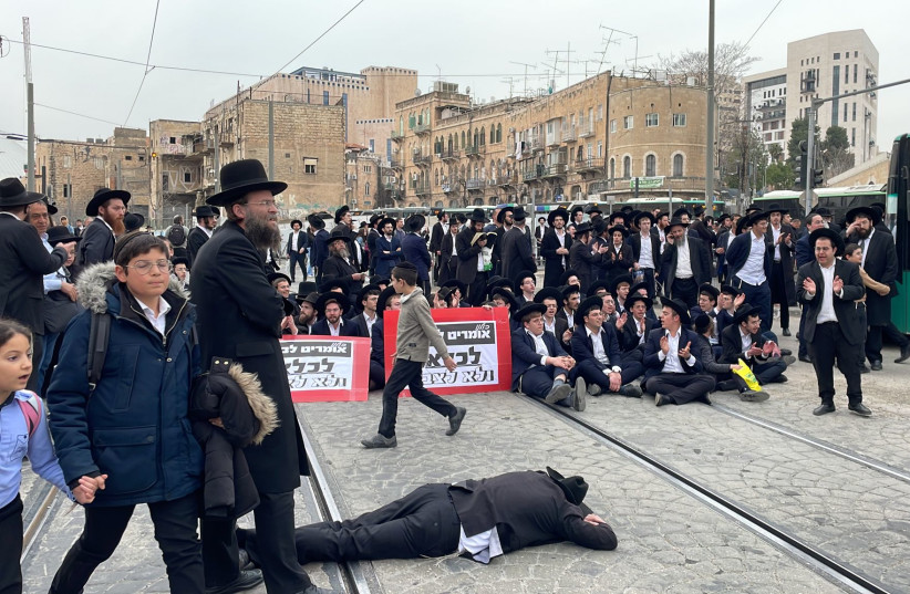 Un grupo de judíos ultraortodoxos bloquea el tráfico y el metro ligero en Jerusalén en una manifestación contra el reclutamiento de haredíes en las FDI. 26 de febrero de 2024. (crédito: SOL SUSSMAN)