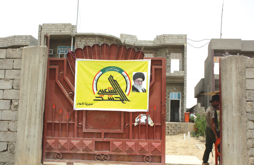  COMBATIENTES DE HEZBOLÁ, con carteles del líder supremo de Irán, Ali Jamenei, son fotografiados por el autor en el cuartel general del grupo Badr en Bagdad en 2015. (credit: JONATHAN SPYER)