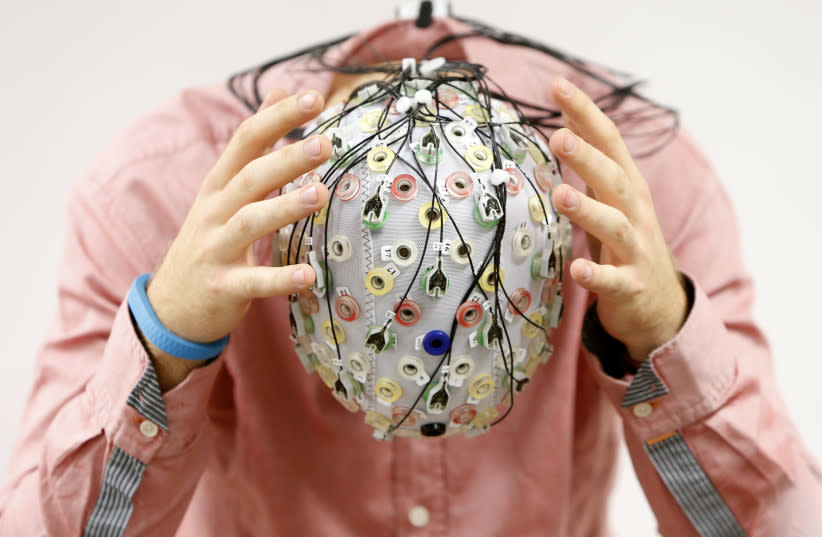  Niklas Thiel posa con un gorro de electroencefalografía (EEG), que mide la actividad cerebral, en la Technische Universitaet Muenchen (TUM) de Garching, cerca de Múnich. (credit: REUTERS/MICHAELA REHLE)