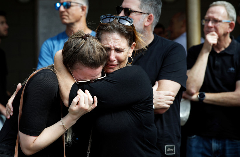 In Kiryat Tivon, family and friends mourn Danielle, 25, and Noam, 26, an Israeli couple who were killed in a deadly attack by Hamas terrorists from Gaza as they attended a festival, as they are buried next to each other at their funeral, October 12, 2023. (credit: REUTERS/SHIR TOREM)