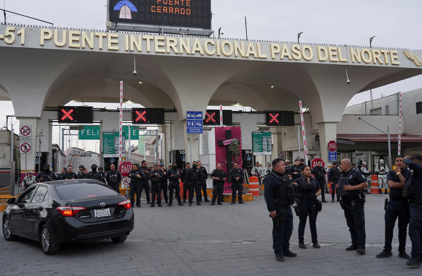  La policía mexicana monta guardia frente a la entrada del Puente Internacional Paso del Norte después de que fuera cerrado por las autoridades mexicanas y estadounidenses después de que los migrantes se reunieran y forzaran su entrada al puente en el centro de Ciudad Juárez, México, 12 de marzo de  (credit: PAUL RATJE/REUTERS)