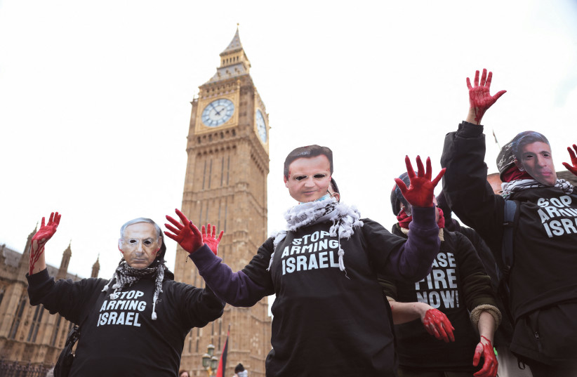  PRO-HAMAS protesters with red paint on their hands wear masks of UK Prime Minister Rishi Sunak, UK Foreign Secretary David Cameron, and Israeli Prime Minister Benjamin Netanyahu as they hold signs reading ‘Stop arming Israel,’ near Big Ben  in London, earlier this year. (credit: HOLLIE ADAMS/REUTERS)