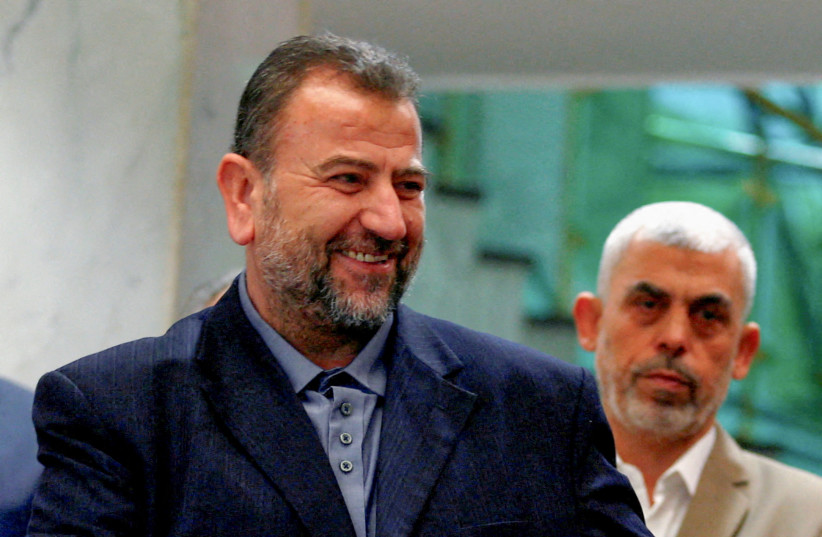  Head of Hamas delegation Saleh al-Arouri, with Gaza's Hamas leader Yahya Sinwar behind him, signs a reconciliation deal with Fatah leader Azzam Ahmad (not pictured), in Cairo, Egypt, October 12, 2017. (credit: REUTERS)