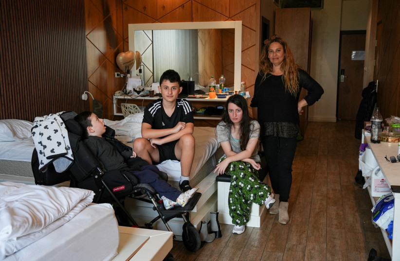  Dekel, Almog, Hadar and their mother, Riki Shusterman, pose for a picture in their temporary accommodation, after being evacuated from their home near the Lebanese border due to the ongoing cross-border hostilities between Hezbollah and Israeli forces, in the village of Regba, Israel, January 8, 20 (credit: Miro Maman/Reuters)
