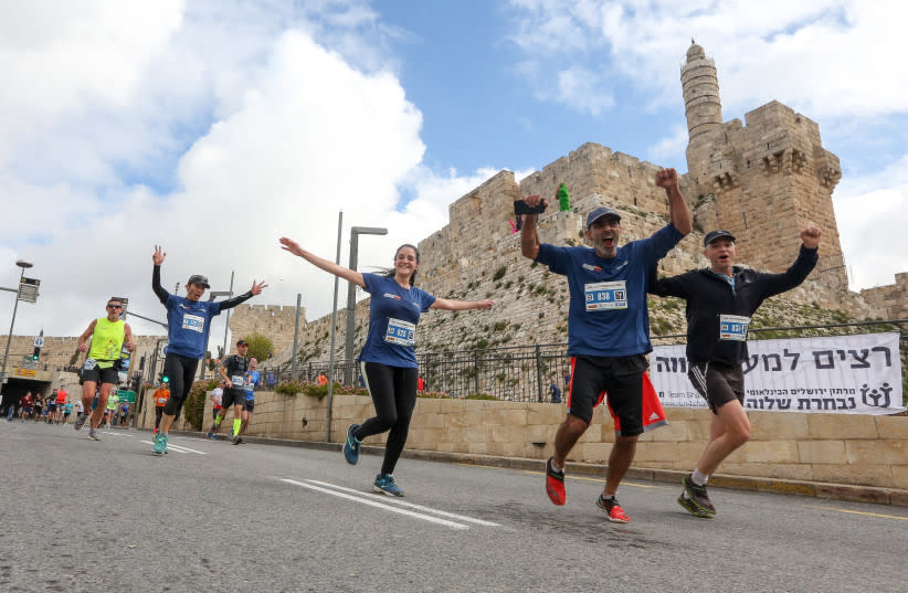 Corredores del Maratón de Jerusalén pasan por delante de las murallas de la Ciudad Vieja de Jerusalén, el 15 de marzo de 2019 (credit: MARC ISRAEL SELLEM/THE JERUSALEM POST)