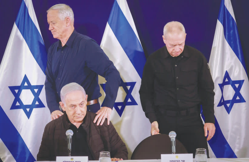  El ministro sin cartera Benny Gantz camina detrás del primer ministro Benjamin Netanyahu, mientras el ministro de Defensa Yoav Gallant ocupa su asiento, en una reciente rueda de prensa. (credit: MARC ISRAEL SELLEM/THE JERUSALEM POST)