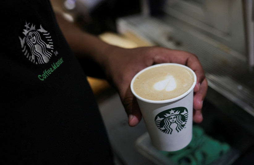  An employee prepares a coffee drink at a Starbucks' outlet at a market in New Delhi, India, May 30, 2023. (credit: REUTERS/ANUSHREE FADNAVIS)
