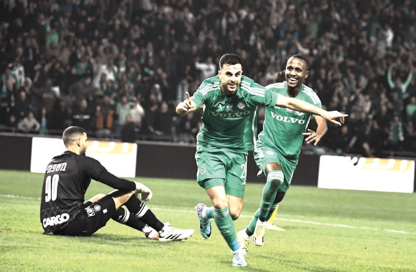 Los compañeros del MACCABI HAIFA Dean David (delante) y Gadi Kinda (derecha) celebran el segundo gol de los verdes sobre el portero del Hapoel Tel Aviv Roie Mishpati (izquierda) durante su victoria por 2-0 sobre los visitantes amarillos y azules en la Premier League el lunes por la noche.