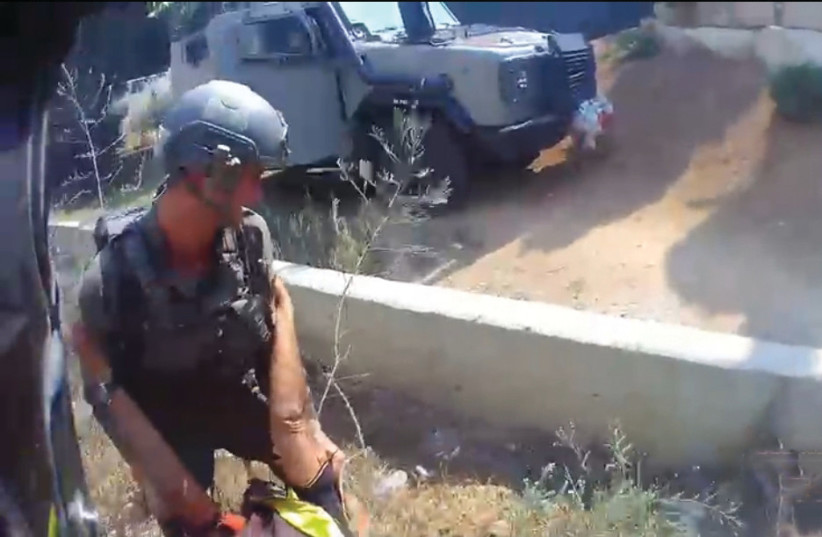  BODYCAM SCREENSHOT of Yosef rescuing a wounded man at 1:12:29 p.m., about an hour before he was killed. (credit: ISRAEL POLICE)