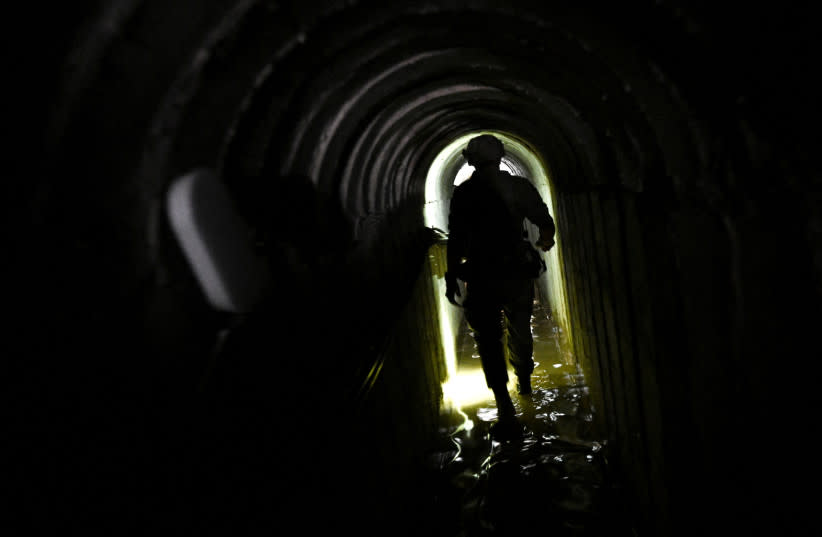  Un soldado israelí camina en lo que el ejército describió como un túnel de comando de Hamas que corre parcialmente bajo la sede de la UNRWA, en medio del conflicto en curso entre Israel y el grupo islamista palestino Hamas, en la Franja de Gaza (credit: DYLAN MARTINEZ/REUTERS)
