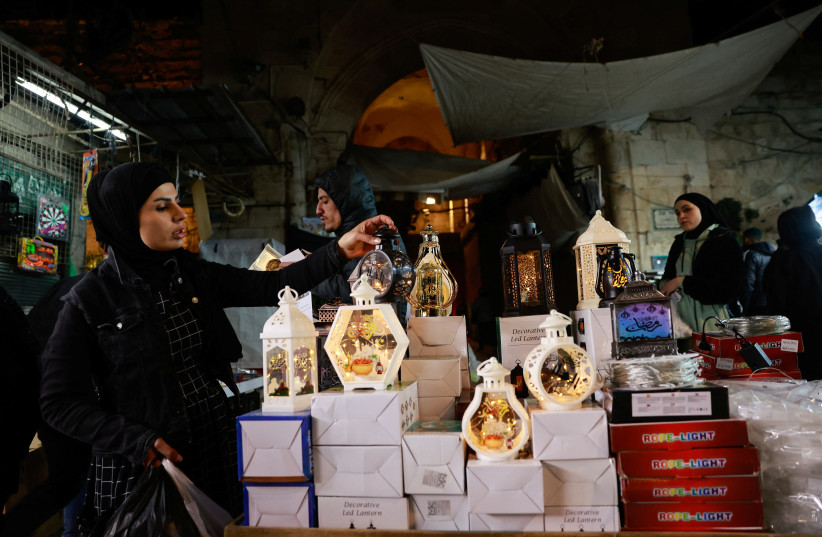  A woman holds a lantern at a market during of the Muslim holy month of Ramadan, in Jerusalem's Old City March 10, 2024.  (credit: AMMAR AWAD/REUTERS)