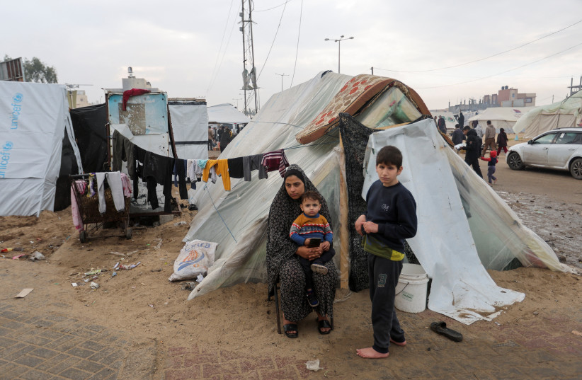  Displaced Palestinians, who fled their houses due to Israeli strikes, shelter in a tent camp, amid the ongoing conflict between Israel and the Palestinian Islamist group Hamas, in Rafah in the southern Gaza Strip, December 25, 2023. (credit: REUTERS/IBRAHEEM ABU MUSTAFA)