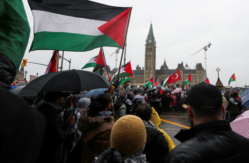  Protesters hold Palestinian flags during a rally to call for a ceasefire, amid the ongoing conflict between Israel and the Palestinian Islamist group Hamas in Gaza, on Parliament Hill in Ottawa, Ontario, Canada March 9, 2024. (credit: REUTERS/Ismail Shakil)