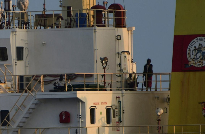  People with weapons stand onboard the Maltese-flagged bulk cargo vessel Ruen seized by Somali pirates, which was intercepted by the Indian Navy, at sea, in this handout photo released on March 16, 2024. (credit: VIA REUTERS)
