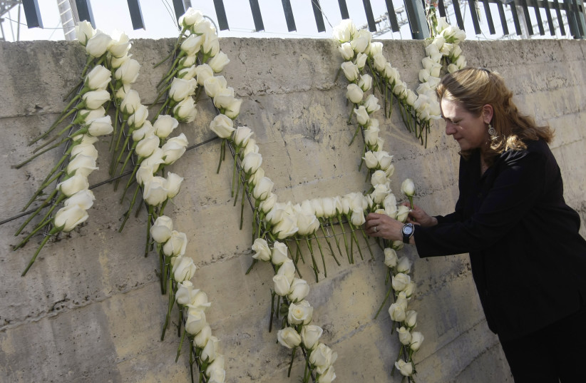  Pilar Manjon, president of the Asociacion 11-M Afectados del Terrorismo (March 11-Victims of Terrorism Association), places a flower during a memorial ceremony at Tellez street just outside Madrid's Atocha train station March 11, 2009. (credit: REUTERS)