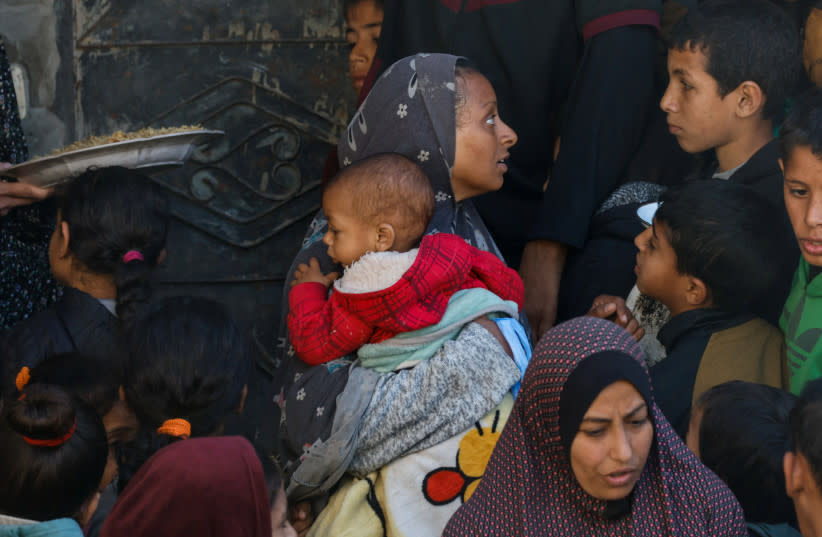  Mujeres y niños palestinos esperan para recibir alimentos, mientras continúa el conflicto entre Israel y el grupo islamista palestino Hamás, en Rafah, en el sur de la Franja de Gaza, 15 de febrero de 2024. (credit: REUTERS/MOHAMMED SALEM)