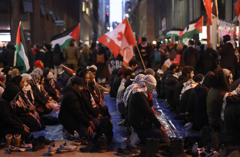  Supporters of a ceasefire in Gaza pray as they gather to protest outside the venue of a Liberal Party fundraising rally featuring Canada's Prime Minister Justin Trudeau, amid the ongoing conflict between Israel and the Palestinian Islamist group Hamas, in Toronto, Ontario, Canada, March 15, 2024.  (credit: REUTERS/CARLOS OSORIO)