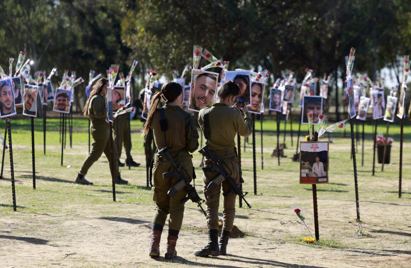  SOLDIERS PAY their respects at the Nova music festival site in November. ‘Beyond the sounds of the shofar, guns, music, prayers, livestock, and bombs, I also heard the whispers,’ says the writer.  (credit: MENAHEM KAHANA / AFP)