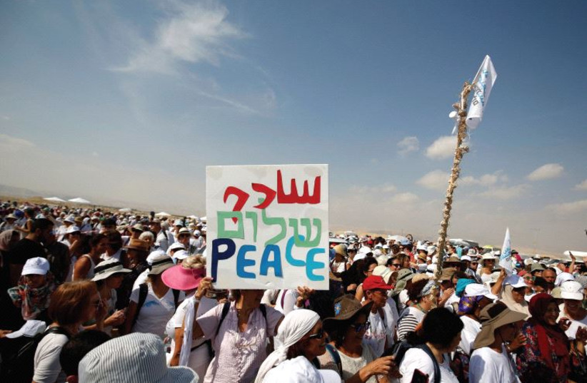  Activistas, entre ellos israelíes y palestinos, participan en una manifestación en favor de la paz cerca de Jericó. (credit: REUTERS)