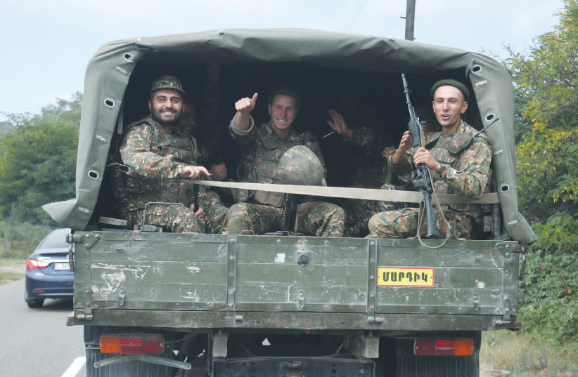  SOLDADOS ARMENIOS viajan en la parte trasera de un camión en la región separatista de Nagorno Karabaj la semana pasada. La región del Cáucaso vivió varias rondas de conflictos tras el colapso de la Unión Soviética, y el conflicto entre Azerbaiyán y Armenia es una de las disputas más notables. (credit: VAHRAM BAGHDASARYAN/REUTERS)