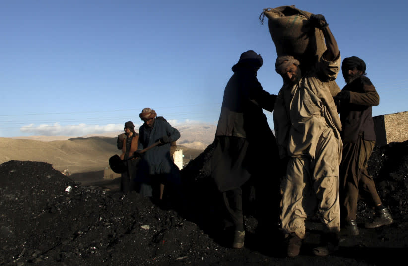  Trabajadores de una mina de carbón llenan sacos de carbón para cargarlos en un camión a las afueras de Quetta, Pakistán 9 de diciembre de 2015. (credit: REUTERS/NASEER AHMED)