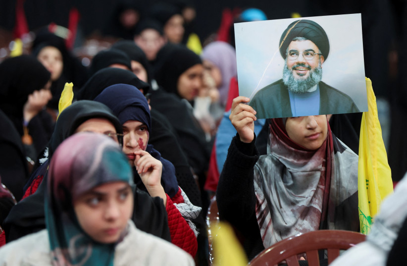  Un simpatizante del líder libanés de Hezbolá, Sayyed Hassan Nasrallah, sostiene su foto durante un mitin en conmemoración de los últimos líderes del grupo en los suburbios del sur de Beirut, Líbano 16 de febrero de 2024. (crédito: MOHAMED AZAKIR/REUTERS)
