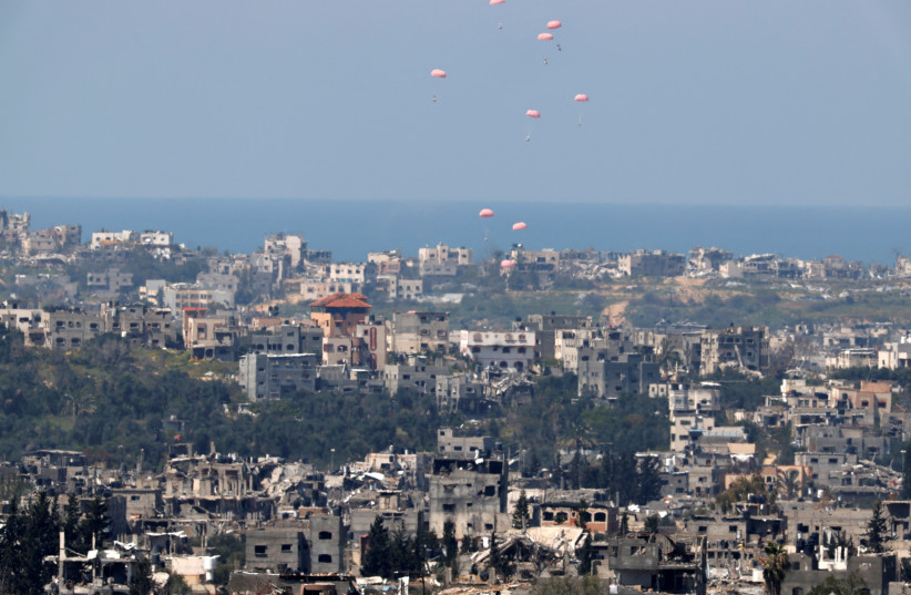  Humanitarian aid falls through the sky towards the Gaza Strip after being dropped from an aircraft, amid the ongoing conflict between Israel and the Palestinian Islamist group Hamas, as seen from Israel's border with Gaza, in southern Israel, March 20, 2024. (credit: AMIR COHEN/REUTERS)