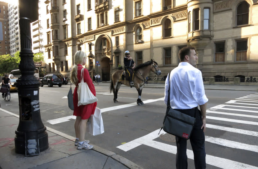  Un policía a caballo espera en un semáforo del barrio Upper West Side de Nueva York 20 de junio de 2013. (credit: GARY HERSHORN/REUTERS)