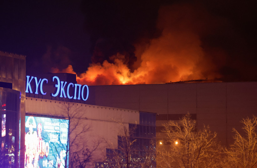 Smoke rises above the burning Crocus City Hall concert venue following a reported shooting incident, outside Moscow, Russia, March 22, 2024.  (credit: MAXIM SHEMETOV/REUTERS)