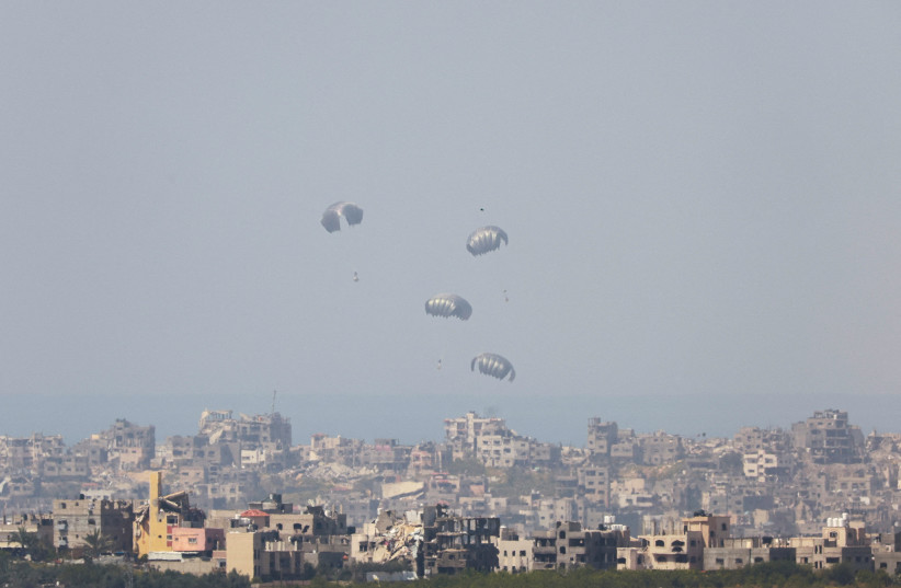  Humanitarian aid falls through the sky towards the Gaza Strip after being dropped from an aircraft, amid the ongoing conflict between Israel and the Palestinian Islamist group Hamas, as seen from Israel's border with Gaza, in southern Israel, March 21, 2024. (credit: AMMAR AWAD/REUTERS)