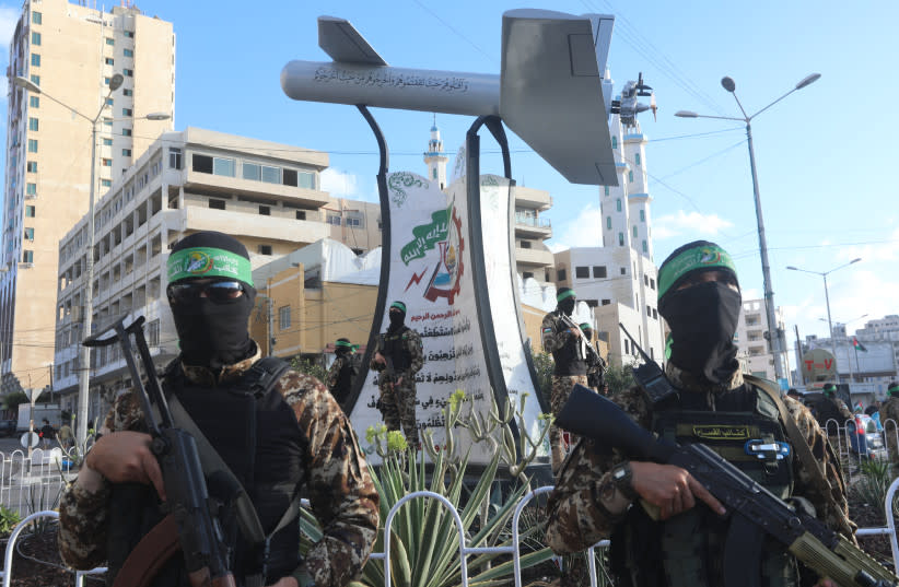  Miembros palestinos de las Brigadas Izz ad-Din al-Qassam, brazo armado del movimiento Hamás, junto a un monumento conmemorativo llamado ''Campo Shehab'', un dron fabricado por al-Qassam, en la ciudad de Gaza, 21 de septiembre de 2022. (credit: ATTIA MUHAMMED/FLASH90)