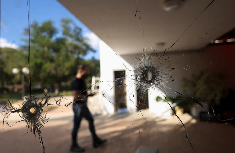  Un hombre camina detrás de un cristal con agujeros de bala tras el mortífero ataque del 7 de octubre perpetrado por hombres armados del grupo militante palestino Hamás desde la Franja de Gaza, en el kibutz Nir Oz, en el sur de Israel, 21 de noviembre de 2023. (credit: RONEN ZVULUN/REUTERS)