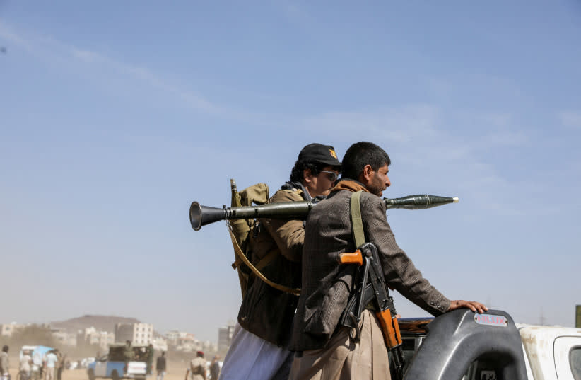 Seguidores armados de los Houthi montan en la parte trasera de una camioneta durante un desfile en solidaridad con los palestinos de la Franja de Gaza y para mostrar su apoyo a los ataques de los Houthi contra barcos en el Mar Rojo y el Golfo de Adén, en Saná, Yemen 29 de enero 2024.