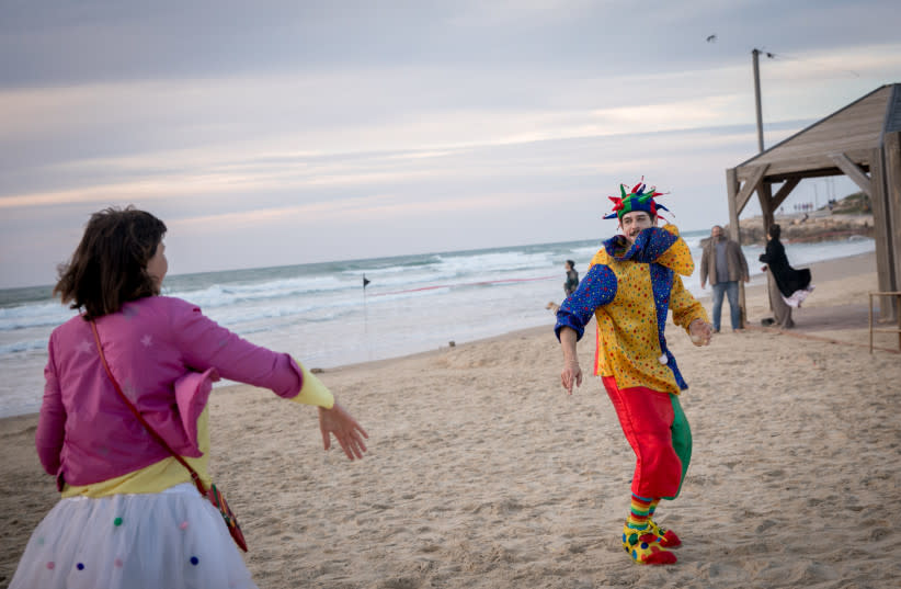 Personas disfrazadas asisten a una fiesta de baile junto a la playa en Tel Aviv, durante la festividad judía de Purim. 23 de marzo de 2024. (credit: MIRIAM ALSTER/FLASH90)