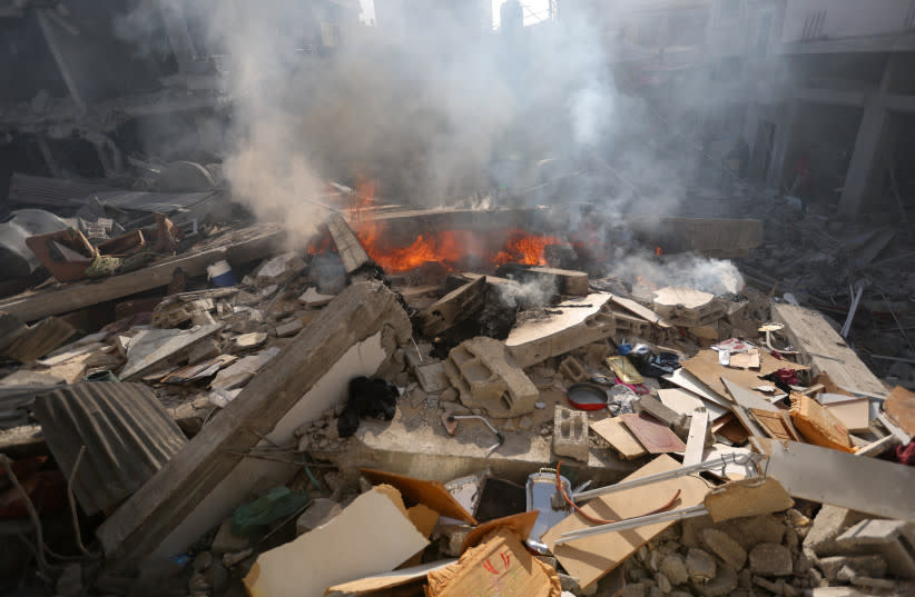  El humo se eleva en el lugar de una casa destruida en un ataque israelí, en medio del conflicto en curso entre Israel y el grupo terrorista palestino Hamás, en Khan Younis, en el sur de la Franja de Gaza, 4 de diciembre de 2023. (credit: REUTERS/IBRAHEEM ABU MUSTAFA)