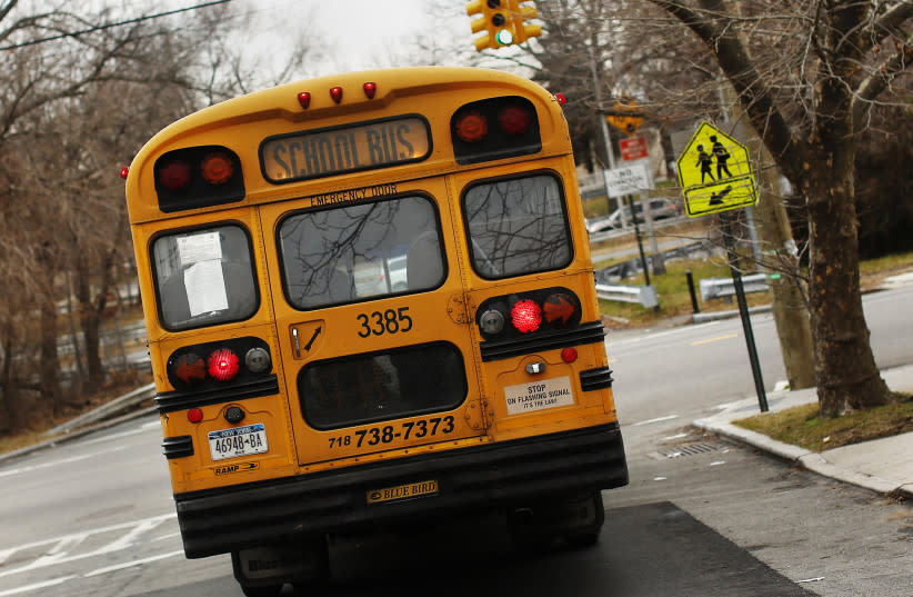 Un autobús escolar utilizado para el transporte de estudiantes de escuelas públicas de Nueva York se ve conduciendo por la avenida 135 en el barrio de Queens de Nueva York.