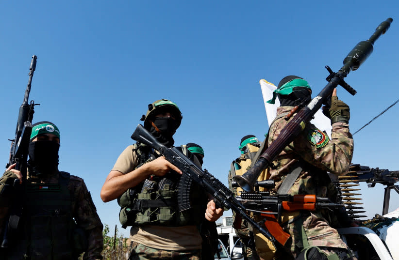 Combatientes palestinos del brazo armado de Hamás participan en un desfile militar con motivo del aniversario de la guerra de 2014 con Israel, cerca de la frontera en el centro de la Franja de Gaza, 19 de julio de 2023. (credit: REUTERS/IBRAHEEM ABU MUSTAFA)