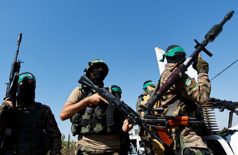 Combatientes palestinos del brazo armado de Hamás participan en un desfile militar con motivo del aniversario de la guerra de 2014 con Israel, cerca de la frontera en el centro de la Franja de Gaza, 19 de julio de 2023.