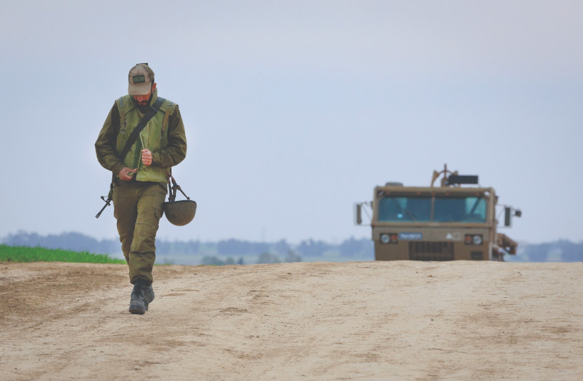 A SOLDIER walks near an IDF Artillery Corps staging area on the border with Gaza