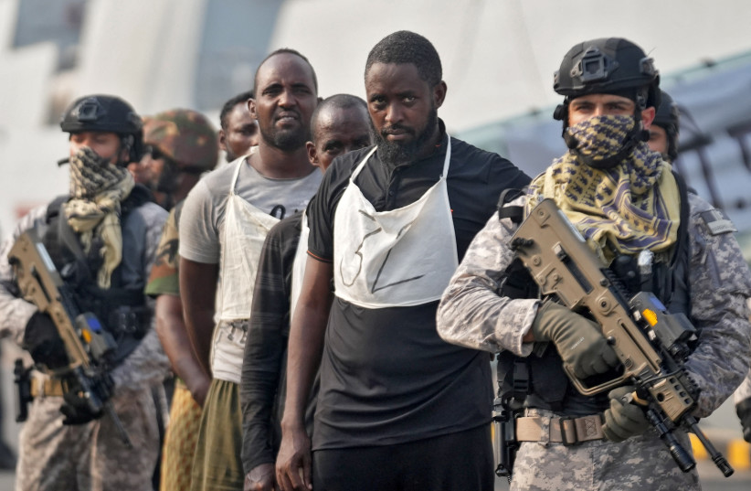 An Indian soldier stands guard next to captured Somali pirates after they were brought in for prosecution by the Indian Navy, at the Naval Dockyard in Mumbai, India, March 23, 2024 (credit: REUTERS/HEMANSHI KAMANI)