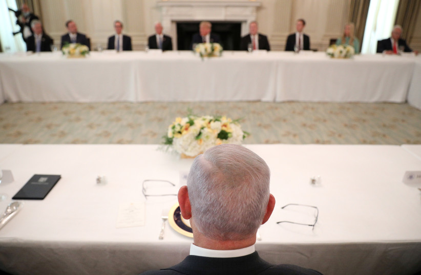  Israel Prime Minister Benjamin Netanyahu looks at U.S. President Donald Trump and other party officials during a luncheon in the State Dining Room following the Abraham Accords Signing Ceremony at the White House in Washington, U.S., September 15, 2020. (credit: TOM BRENNER/REUTERS)