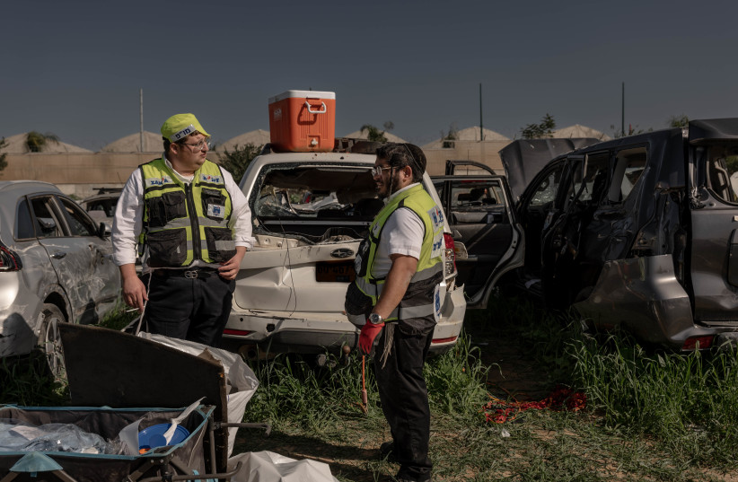  Zaka personnel work at a field with destroyed cars from the October 7 massacre, near the Israel-Gaza border, January 22, 2024. (credit: CHEN SCHIMMEL/FLASH90)
