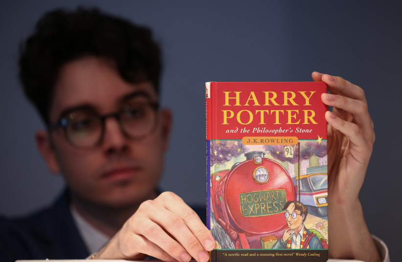 Rare Books Specialist and curator Mark Wiltshire poses with a rare first edition and signed by the author copy of 'Harry Potter and the Philosophers Stone' by British author J.K. Rowling, which is to be put up for auction at Christie's auction house in London, Britain May 31, 2022. (credit: REUTERS/HENRY NICHOLLS)